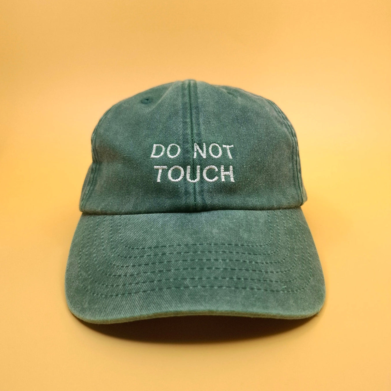 Grüne Vintage Cap bestickt mit dem Text "DO NOT TOUCH" in weiss