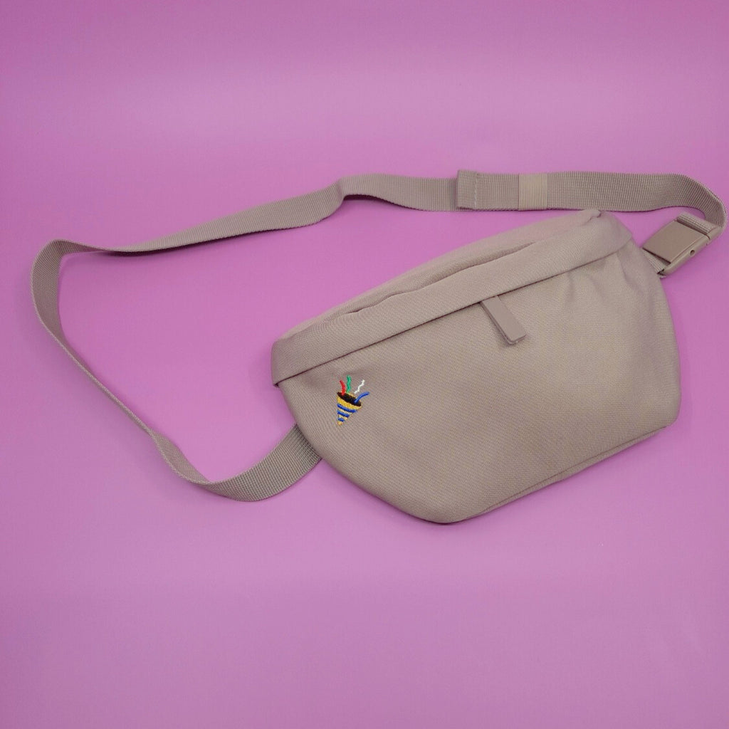 Braune Bauchtasche mit einem Konfetti-Icon darauf gestickt.