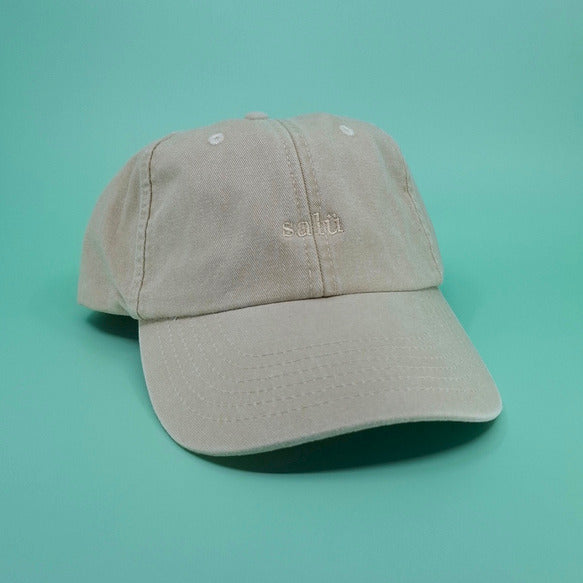 Beige Cap mit dem Text "salü" darauf gestickt in beige.