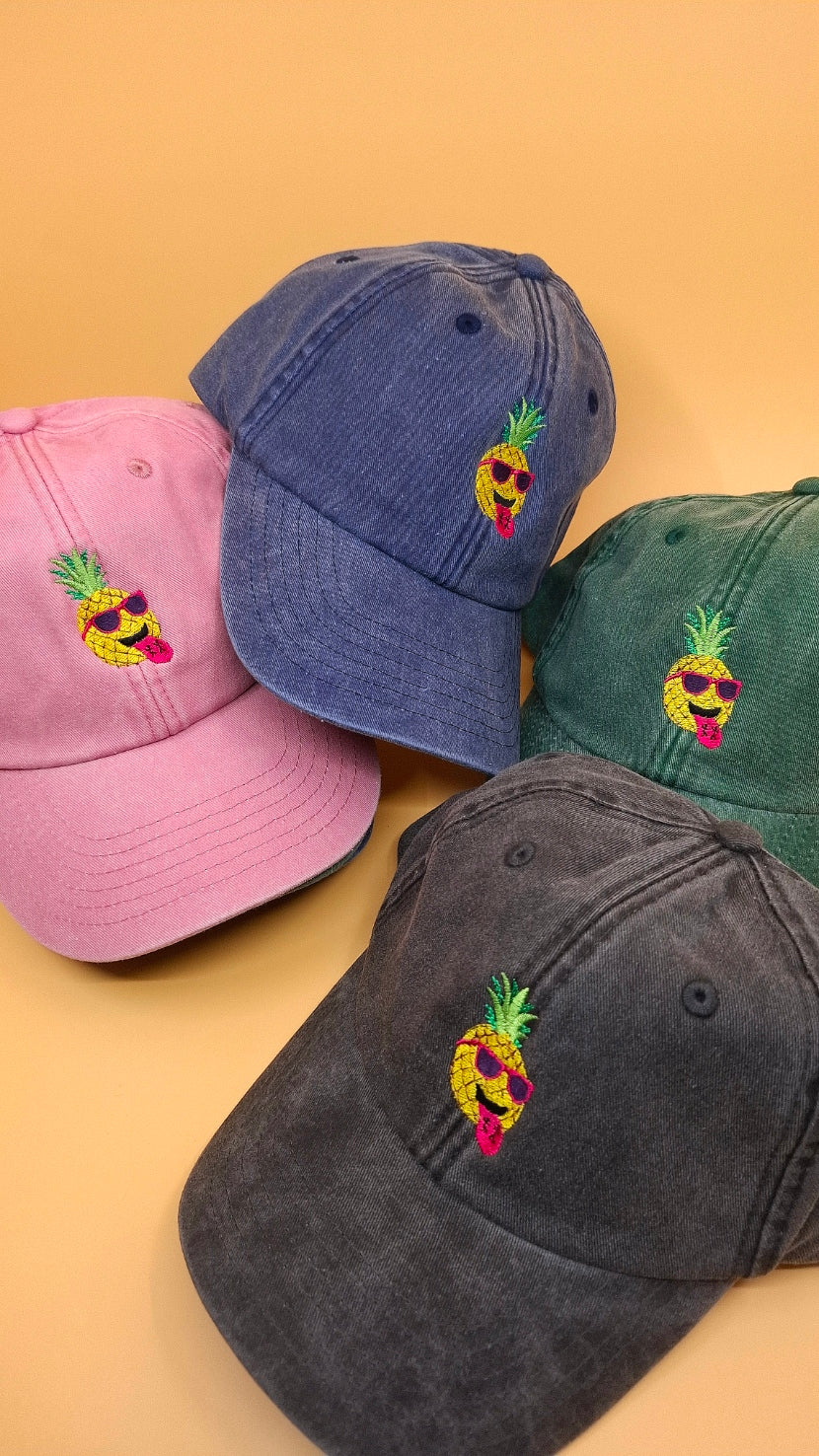 4 Caps in schwarz, rosa, grün und blau. Alle Caps haben eine Ananas ist darauf gestickt.