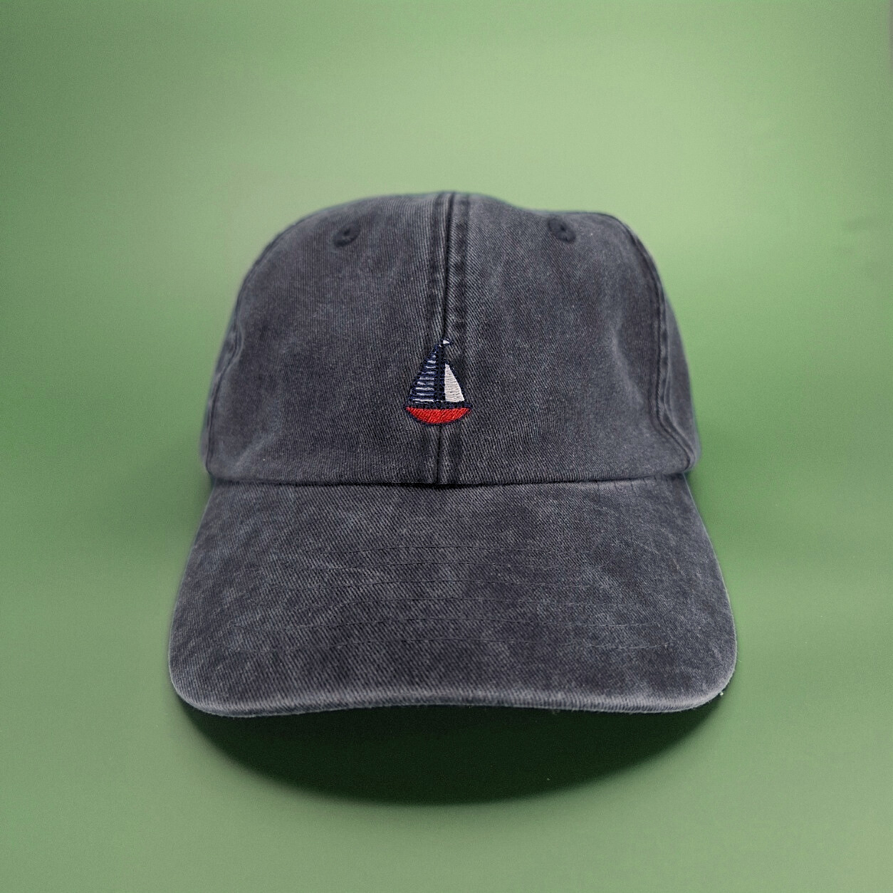 Schwarze Cap mit einem Segelboot-Icon als Stickerei.