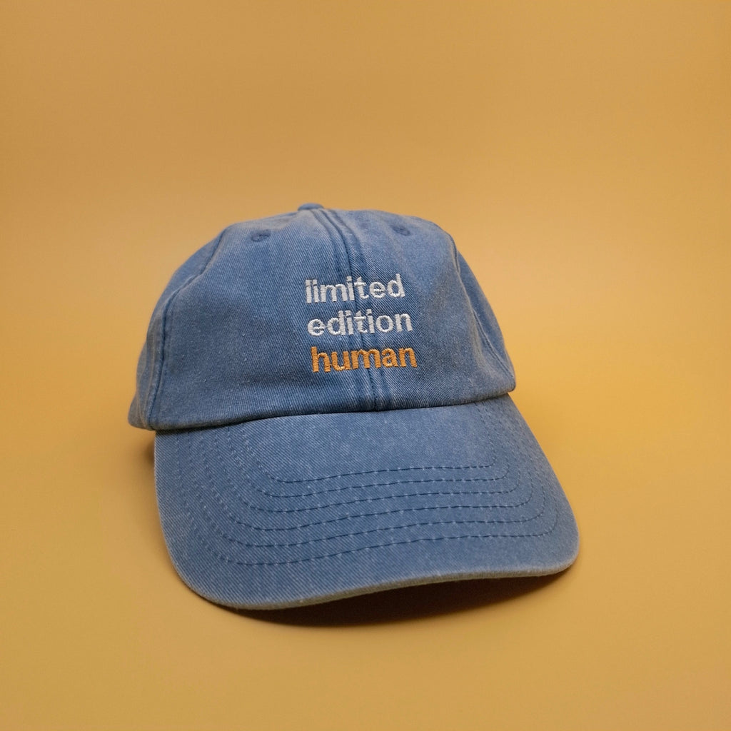 Blaue Cap mit besticktem Text "limited edition human"